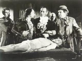 Dermot Walsh, Pleasence, Peter Cushing, and Rose examine the body